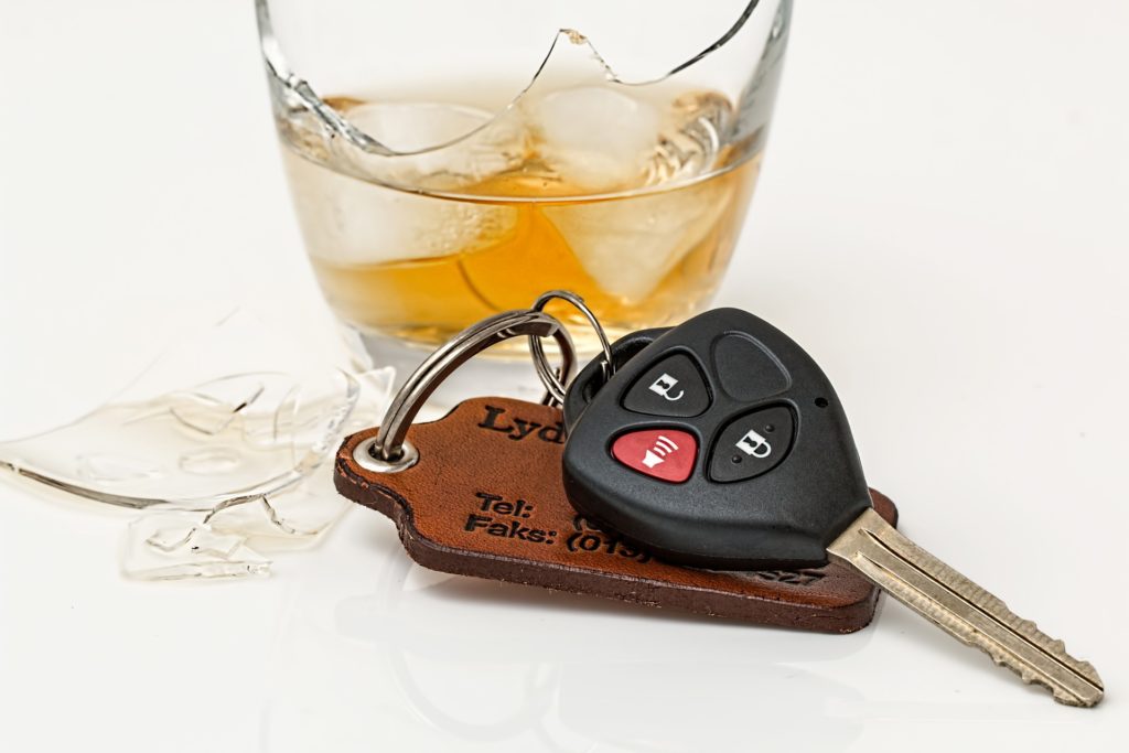 How long will a DUI stay on your record? Stock image of a broken glass with ice and amber liquid inside it and a set of car keys by Steve Buissinne from Pixabay